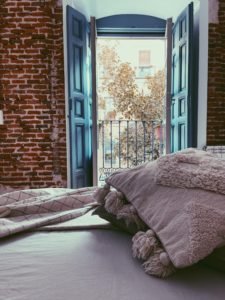 vista de la cama a una pared y ventana en madrid