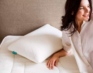 mujer sobre colchón y almohada blancas