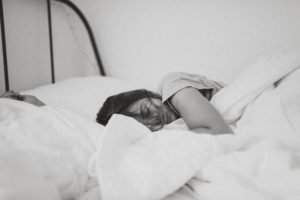 mujer descansando sobre una cama