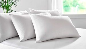 4 almohadas blancas en un colchón