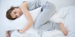 mujer durmiendo en posición fetal