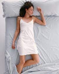 mujer con bata blanca durmiendo boca arriba