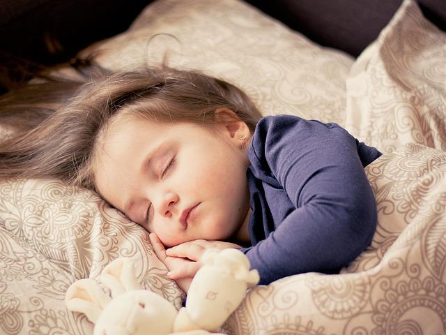 niña durmiendo de lado con un osito