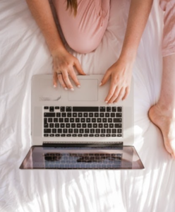 una mujer en la cama con una laptop