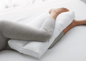 mujer con almohada entre piernas