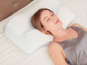mujer acostada boca arriba sobre almohada cervical