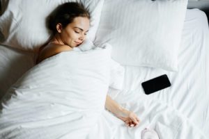 mujer dormida con el movil en la cama