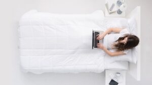 mujer acostado con laptop en la cama