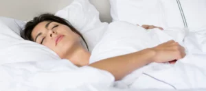 mujer durmiendo boca arriba en medio de almohadas