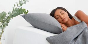 mujer durmiendo con almohada alta 