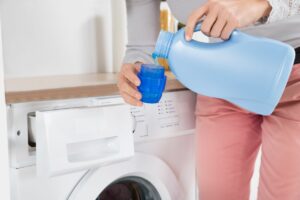 persona usando detergente para lavadora