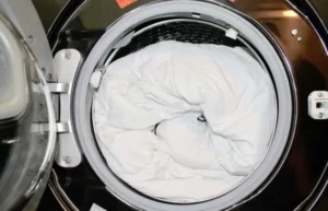 edredon blanco dentro de la lavadora