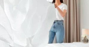 mujer colocando sabana limpia a la cama