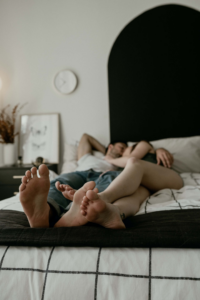 pareja abrazados en la cama con los pies cruzados entre ellos