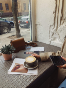 taza de cafe sobre una foto con una planta y un movil sobre la mesa