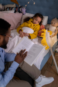 niños acostados y papa leyendo cuentos