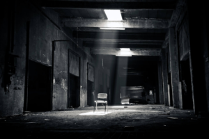 pasillo oscuro con varias puertas y sillas al fondo