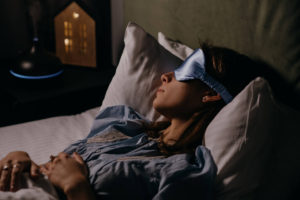 mujer dormida boca arriba con antifaz azul seda  