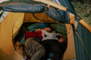 pareja durmiendo dentro de un saco abierto al aire libre