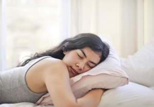 mujer durmiendo boca abajo abrazando la almohada