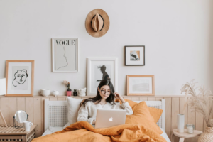 mujer con anteojos leyendo en la laptop arriba de la cama
