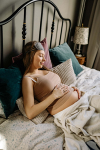 mujer embarazada con varias almohadas semisentada en la cama